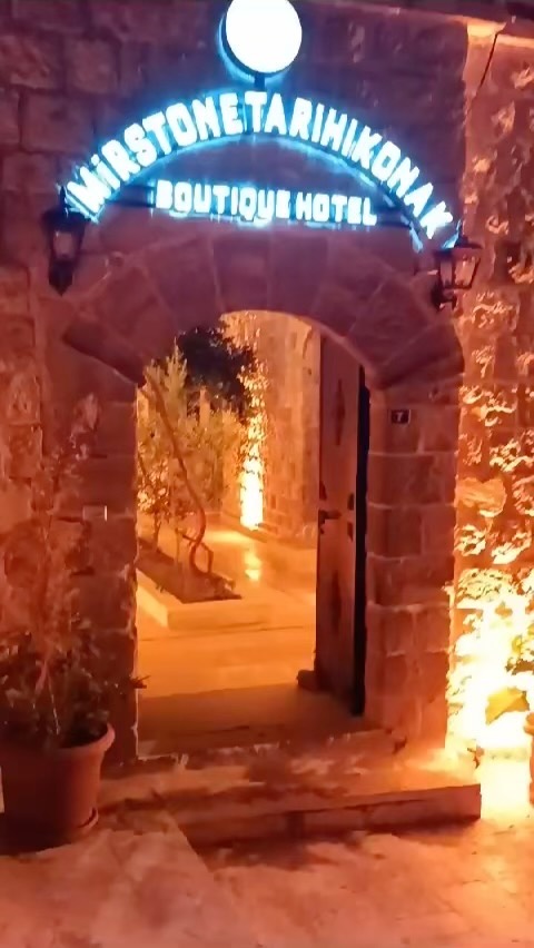Gece ışıklı MîrStone Tarihi Konak tabelası ve taş kemerli giriş kapısı