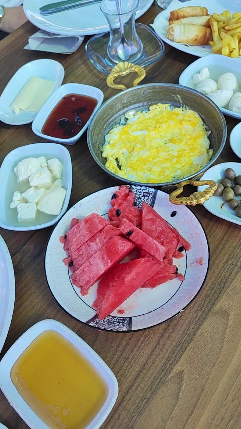 Kahvaltı sofrası: bakır sahanda yumurta, beyaz peynir, karpuz, zeytin, bal ve reçel